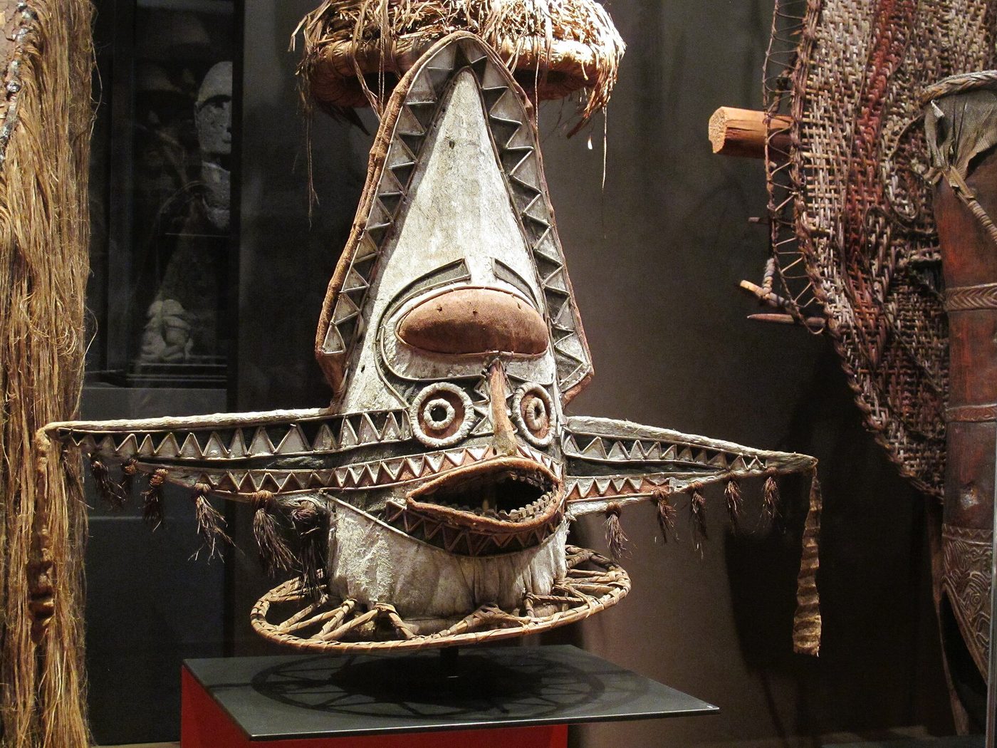 Máscara ceremonial kovave del pueblo elema, cónica, pintada de blanco con dientes de sierra y grandes alas laterales