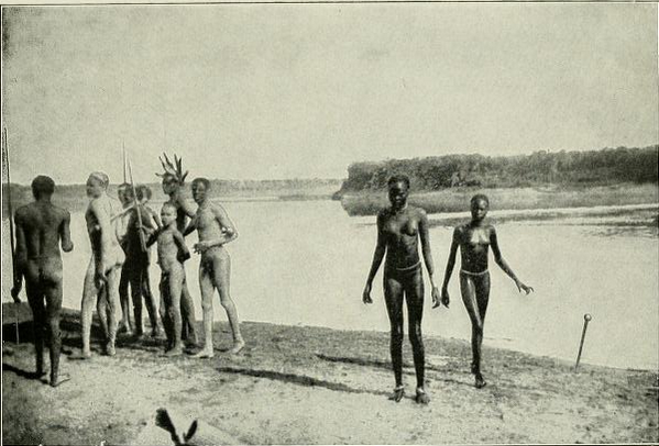 Fotografía de principios del siglo XX de un grupo de personas en la orilla de un río, en el Sudán