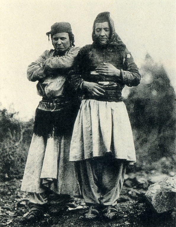 Fotografía de 1929 de dos personas en el campo, una de ellas con gorro y ropa masculina, la otra con vestido tradicional