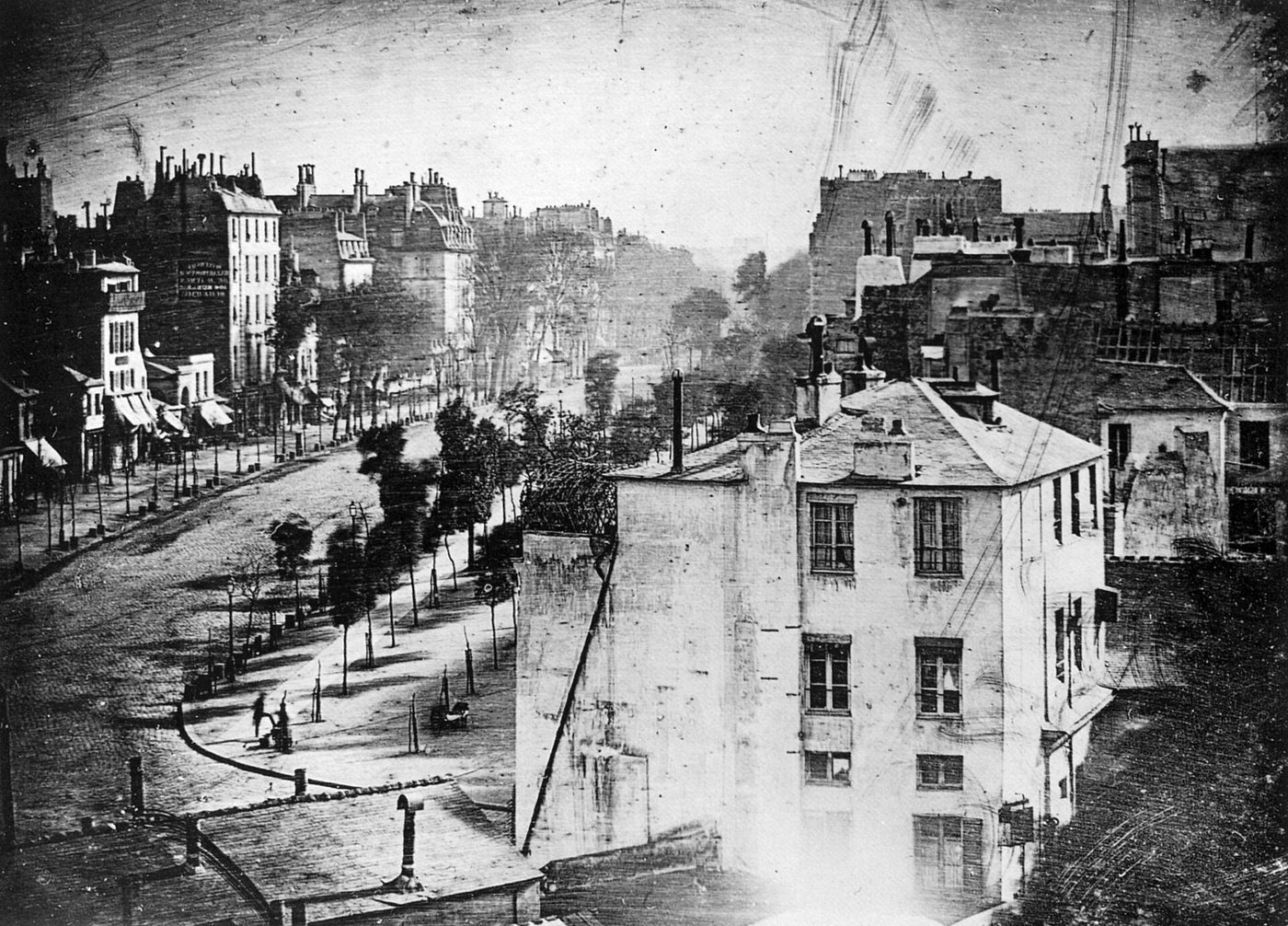 Daguerrotipo del Boulevard du Temple de París, con la calzada vacía y un limpiabotas junto a un banco