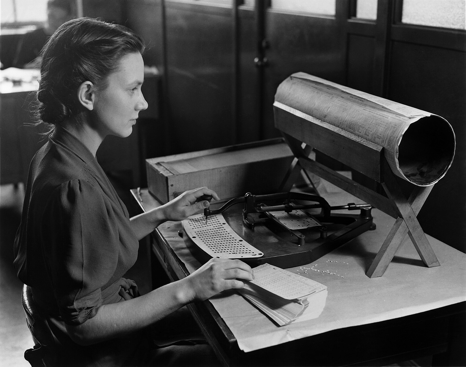 Una operadora del censo de Estados Unidos perfora tarjetas hacia 1940. Los ordenadores de relés de los Laboratorios Bell leían datos de tarjetas y cinta perforadas, y un agujero mal leído bastaba para arruinar un cálculo; el código de Hamming nació para que la máquina siguiera trabajando sin nadie que vigilara.