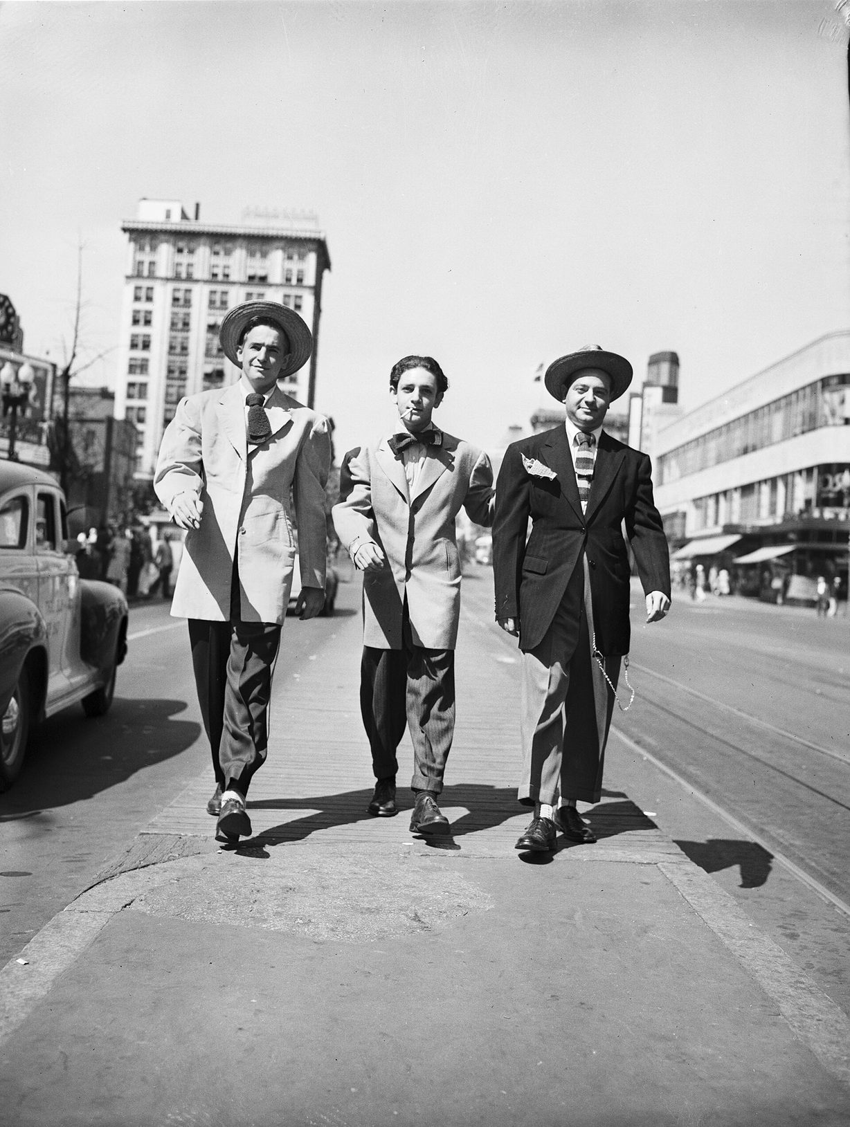 Fotografía de los años cuarenta de varios jóvenes posando en la calle con trajes de chaqueta desmesurada, pantalón de pinza muy ancho y cadena larga